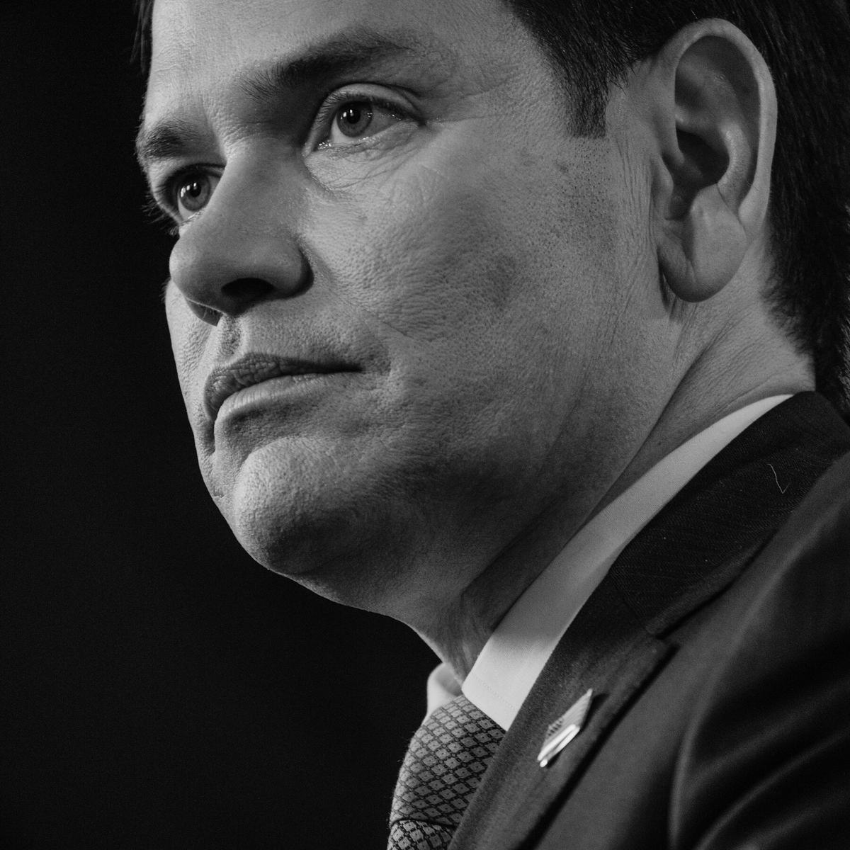 Black-and-white portrait of Marco Rubio, U.S. Secretary of State. Filed as the officer who holds the pump.